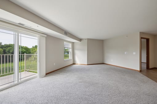 an empty living room with sliding glass doors to a balcony