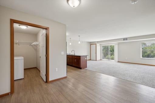 an open living room and kitchen with wood floors and white walls