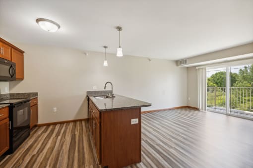 an empty kitchen and living room with a large window