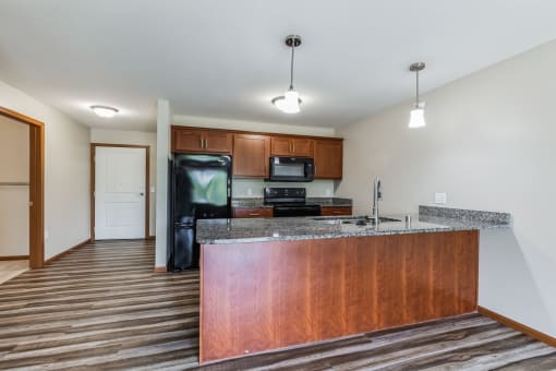 a kitchen with a granite counter top and a black refrigerator