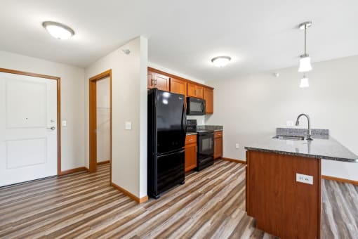 a kitchen with a black refrigerator and a counter top