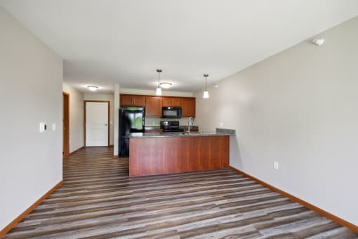 a spacious living room with a kitchen with a wood floor