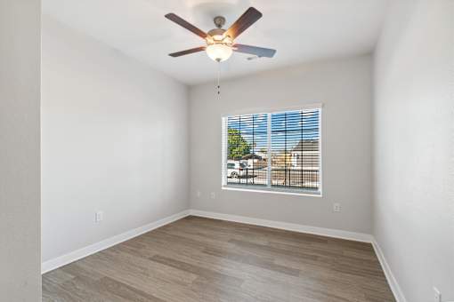 Bedroom with a ceiling fan and a window.