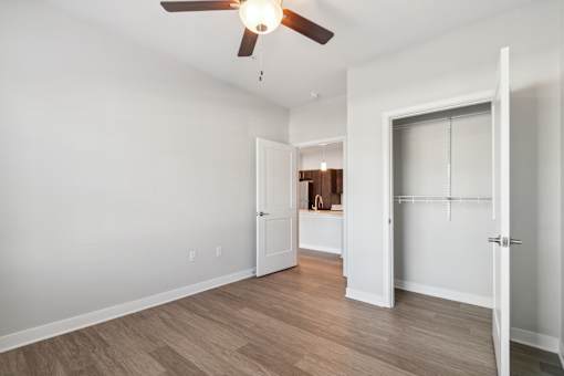 A room with a ceiling fan and wooden flooring.