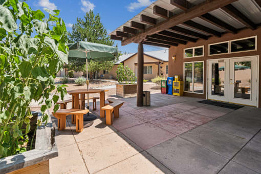 A patio with a table and chairs under a roof.