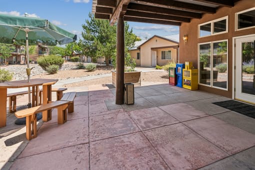the back patio of a house with a picnic table and a table umbrella