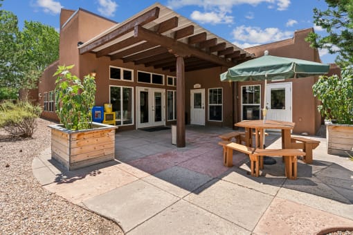 A patio area with a table and chairs under a pergola.