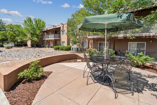 a patio with a table and chairs and an umbrella