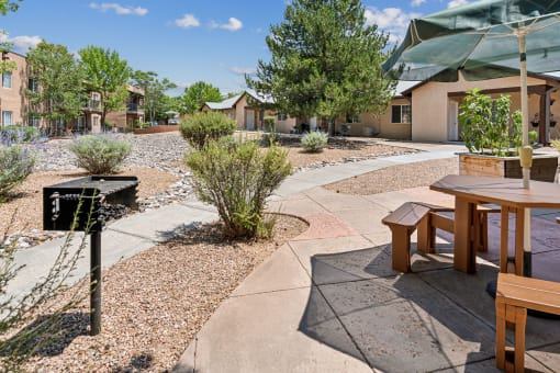 a patio with tables and benches in front of a building
