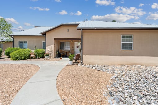 A house with a gravel driveway and a paved walkway leading to the front door.