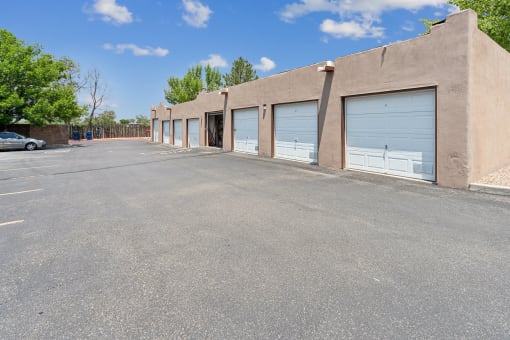 an empty parking lot in front of a building with garage doors