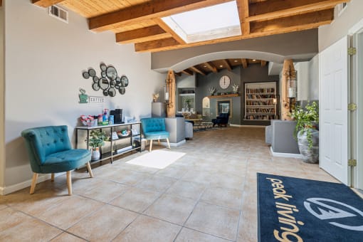 a lobby with blue chairs and a rug in the center of it