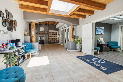 a living room with blue chairs and a rug and a fireplace