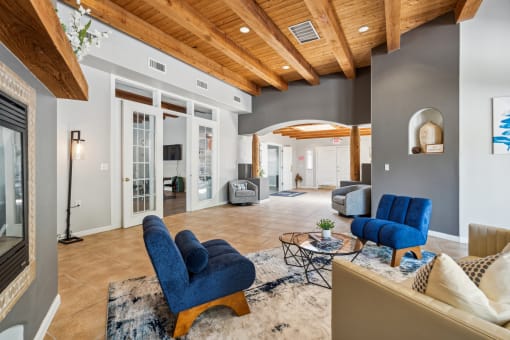 a living room with blue chairs and a rug and a fireplace