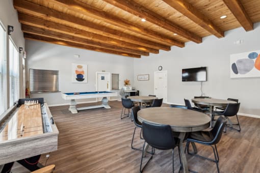 a room with tables and chairs and a pool table in the corner