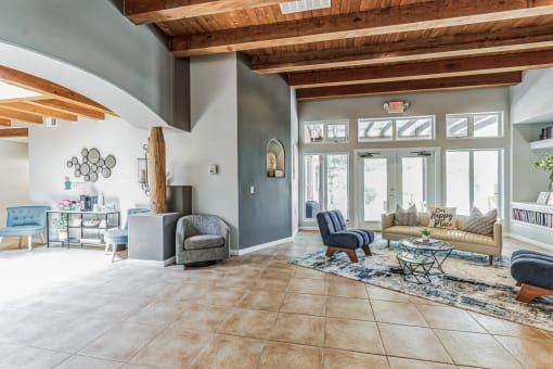 A living room with a couch, chairs, and a rug.