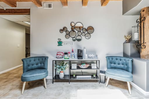 A living room with two blue chairs and a grey sofa.