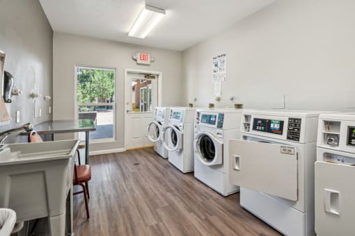 A laundromat with a row of washers and dryers.