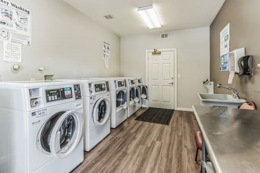 A laundromat with a row of washers and a counter.