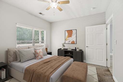 A bedroom with a bed, nightstand, and a ceiling fan.