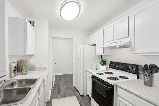 A kitchen with white cabinets and a black stove top oven.