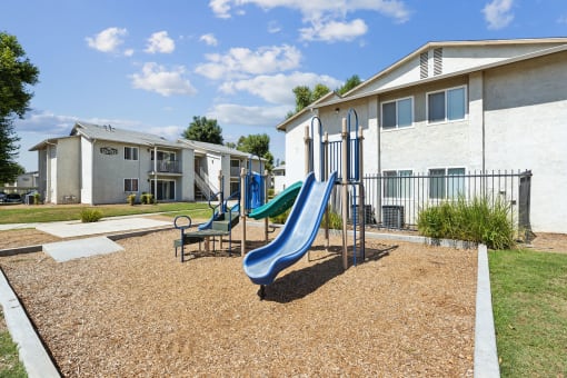our apartments have a playground with a slide and chairs