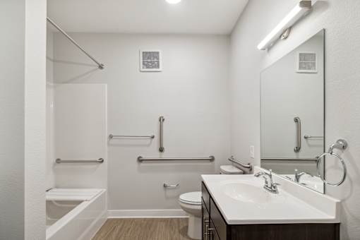 A white bathroom with a toilet, sink, and shower.