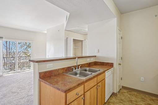 A kitchen with a brown counter top and white cabinets.