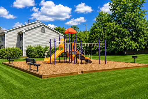 A playground with a yellow slide and purple poles.
