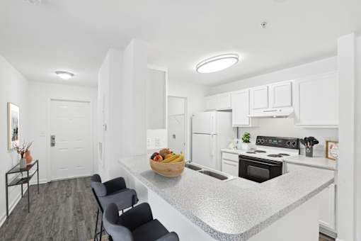 A kitchen with a bowl of fruit on the island.