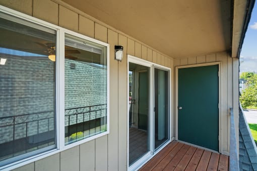 a covered porch with sliding glass doors and a deck