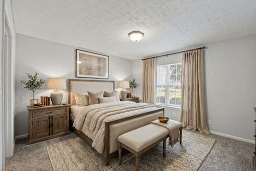 A bedroom with a large bed, a bench, and a side table with a plant.