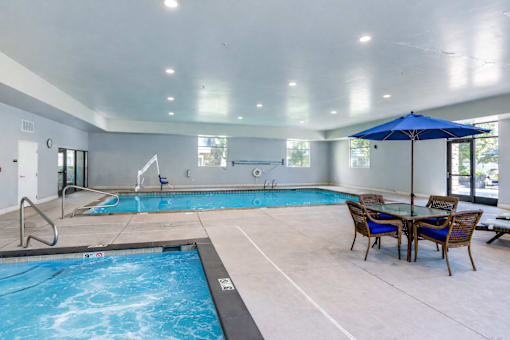 Indoor pool with hot tub and seating area at The Beckstead Apartments, South Jordan