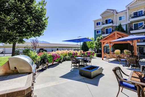 Outdoor patio with fire pit and pergola seating at The Beckstead Apartments, South Jordan, UT
