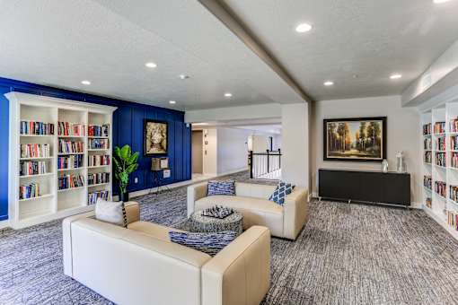 Library lounge with white bookshelves and seating at The Beckstead Apartments, South Jordan, 84095