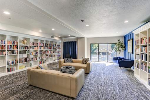 Community library lounge with extensive book collection at The Beckstead Apartments, South Jordan, Utah