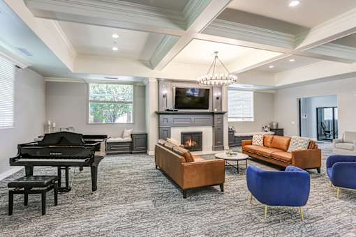 Elegant lounge area with grand piano and fireplace at The Beckstead Apartments, Utah