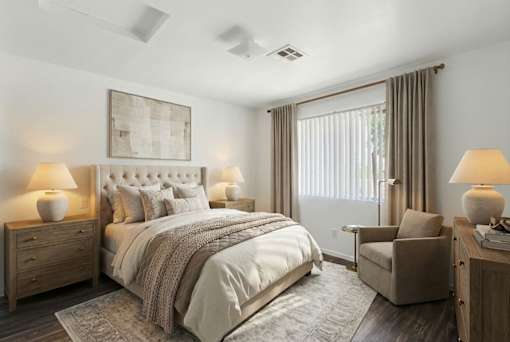 A bedroom with a large bed, a chair, and a painting on the wall.