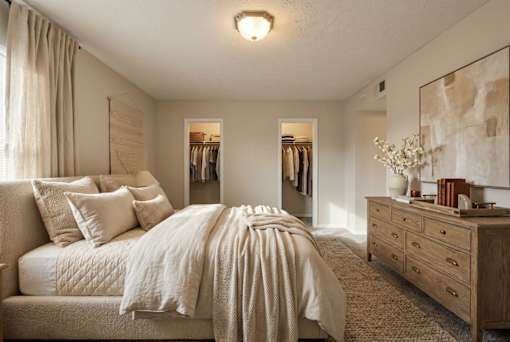 A bedroom with a large bed and a dresser.
