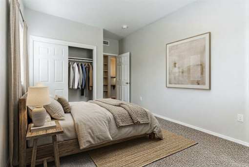 A bedroom with a bed, nightstand, and a ceiling fan.