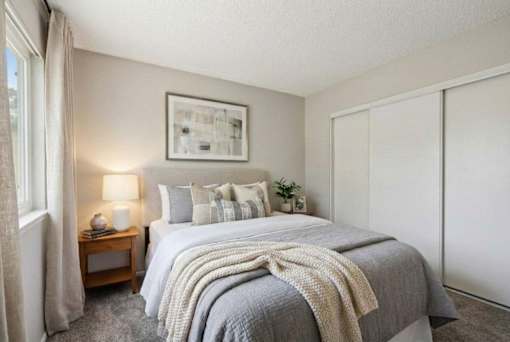 A bedroom with a large bed and a painting on the wall.