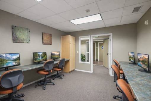 A conference room with a carpeted floor and a long table with chairs on either side.