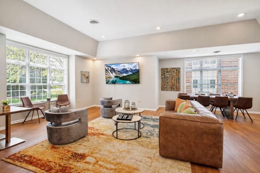 A living room with a brown couch and a rug.