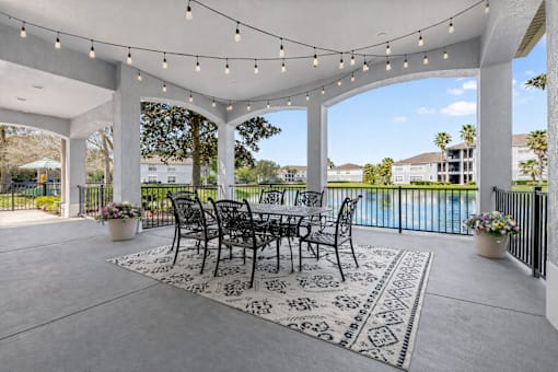 A patio with a table and chairs under string lights.