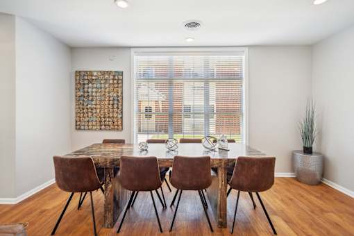A dining room with a table and chairs.