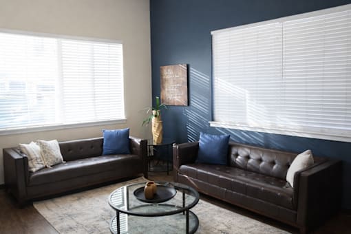 A living room with a brown couch and a coffee table.