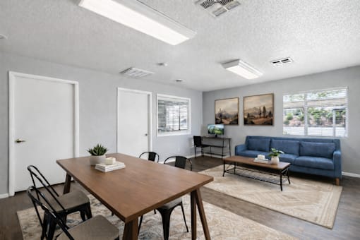 A living room with a blue couch and a wooden table.