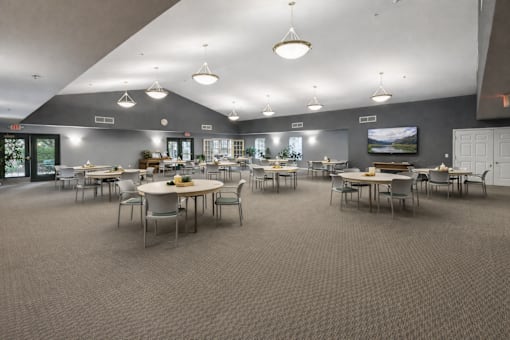A large room with tables and chairs is shown.
