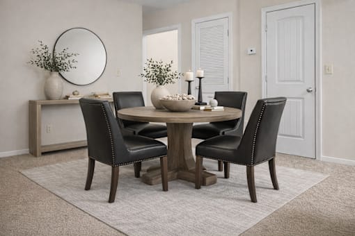 A dining room with a round table and chairs.