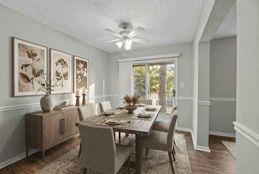 A dining room with a table set for four.